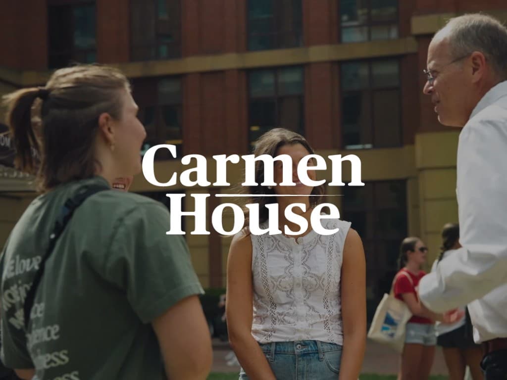 Students and a mentor talking outside Carmen House on the Ohio State campus.
